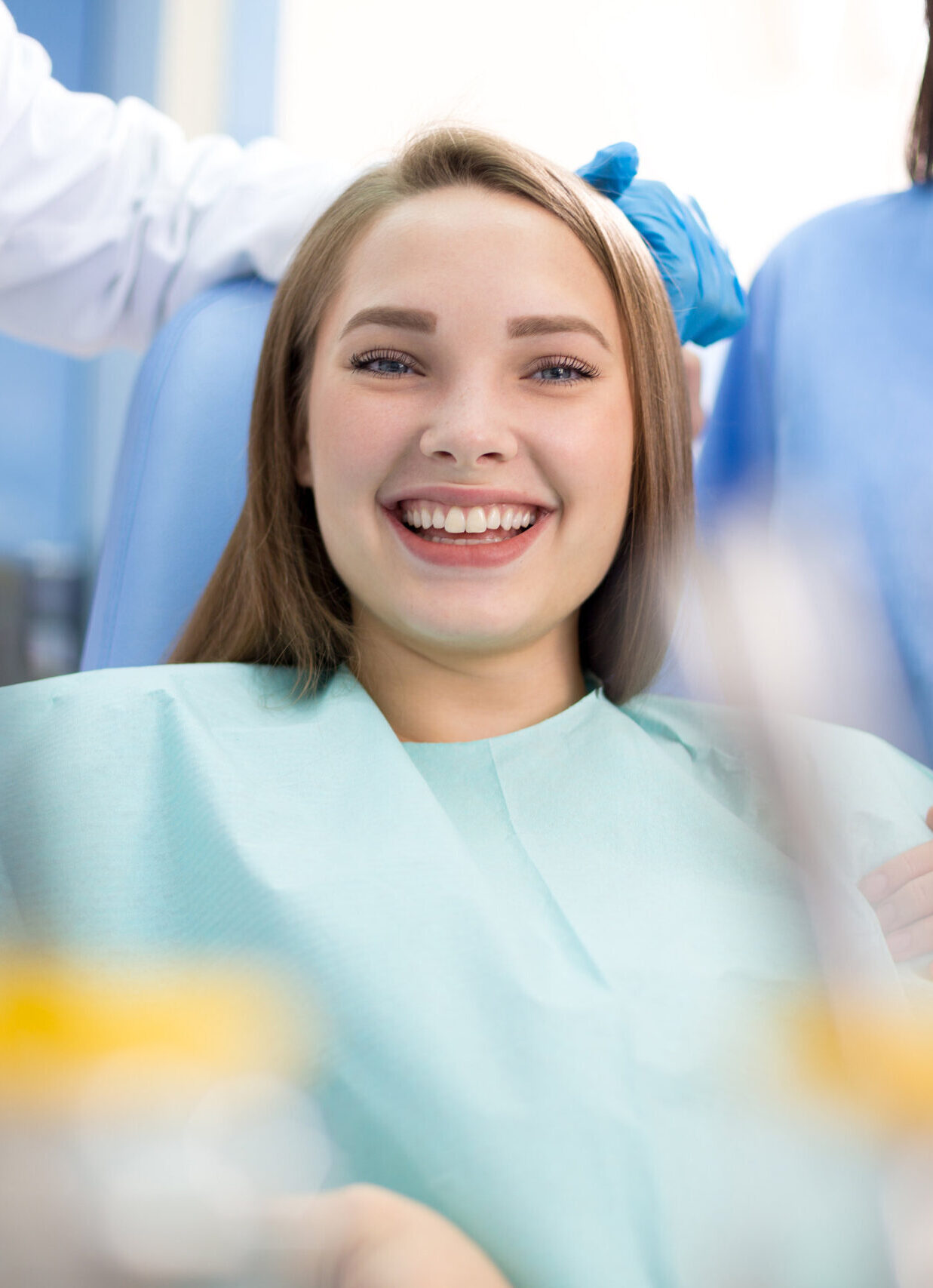 Happy girl in dental chair after treatment when pain stopped in clinic