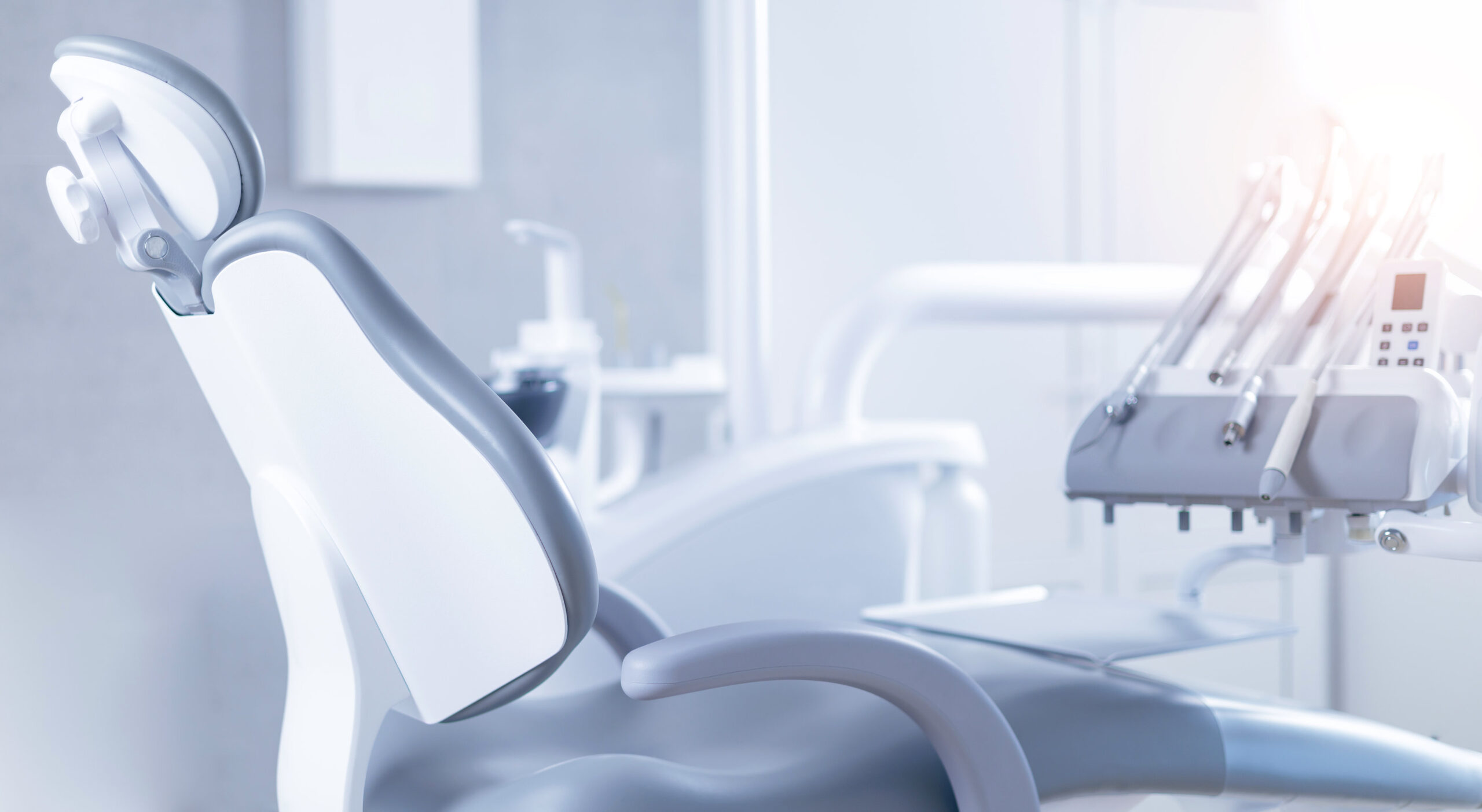Modern dental office equipment in bright clinical setting with sunlight.