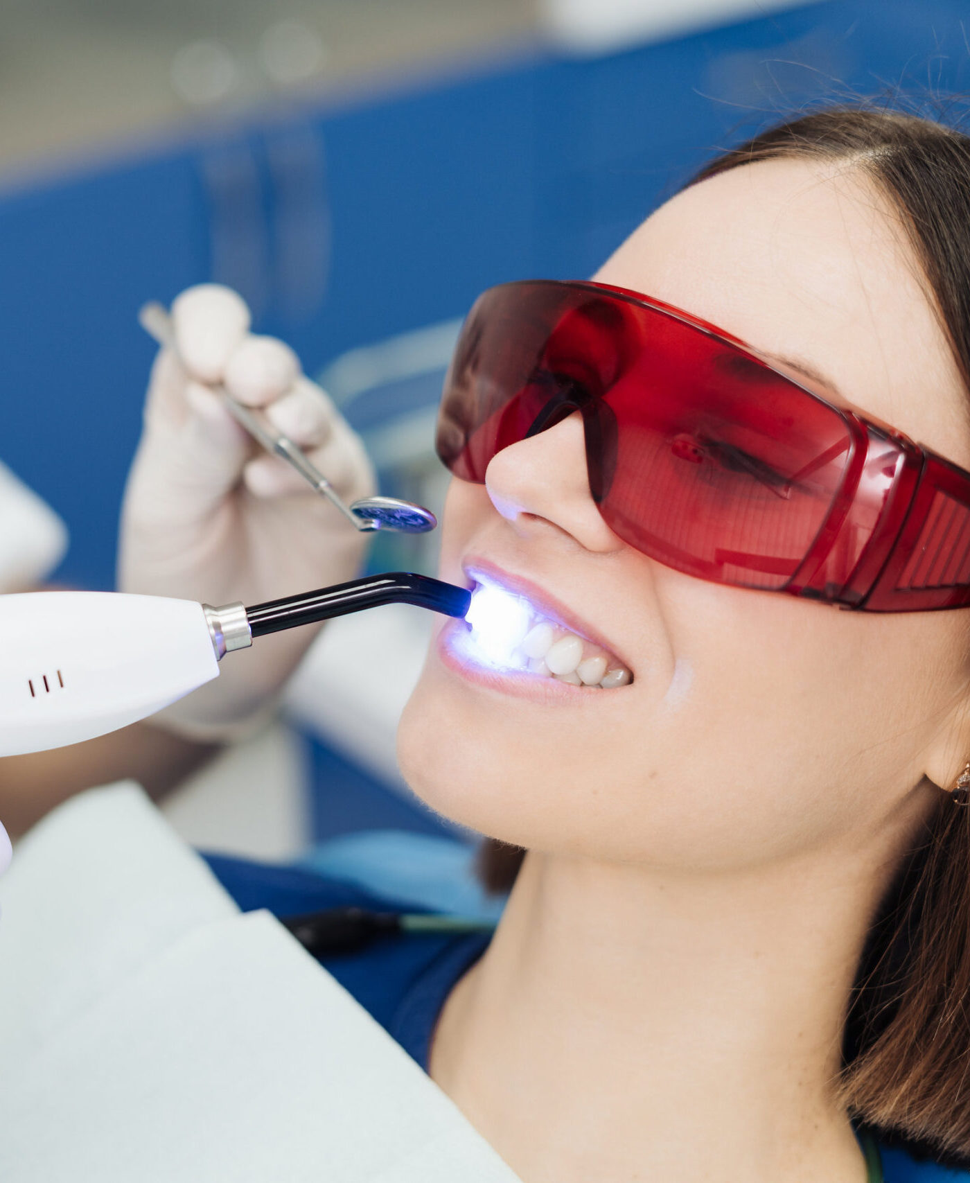 Close-up portrait of a female patient visiting dentist for teeth whitening in clinic