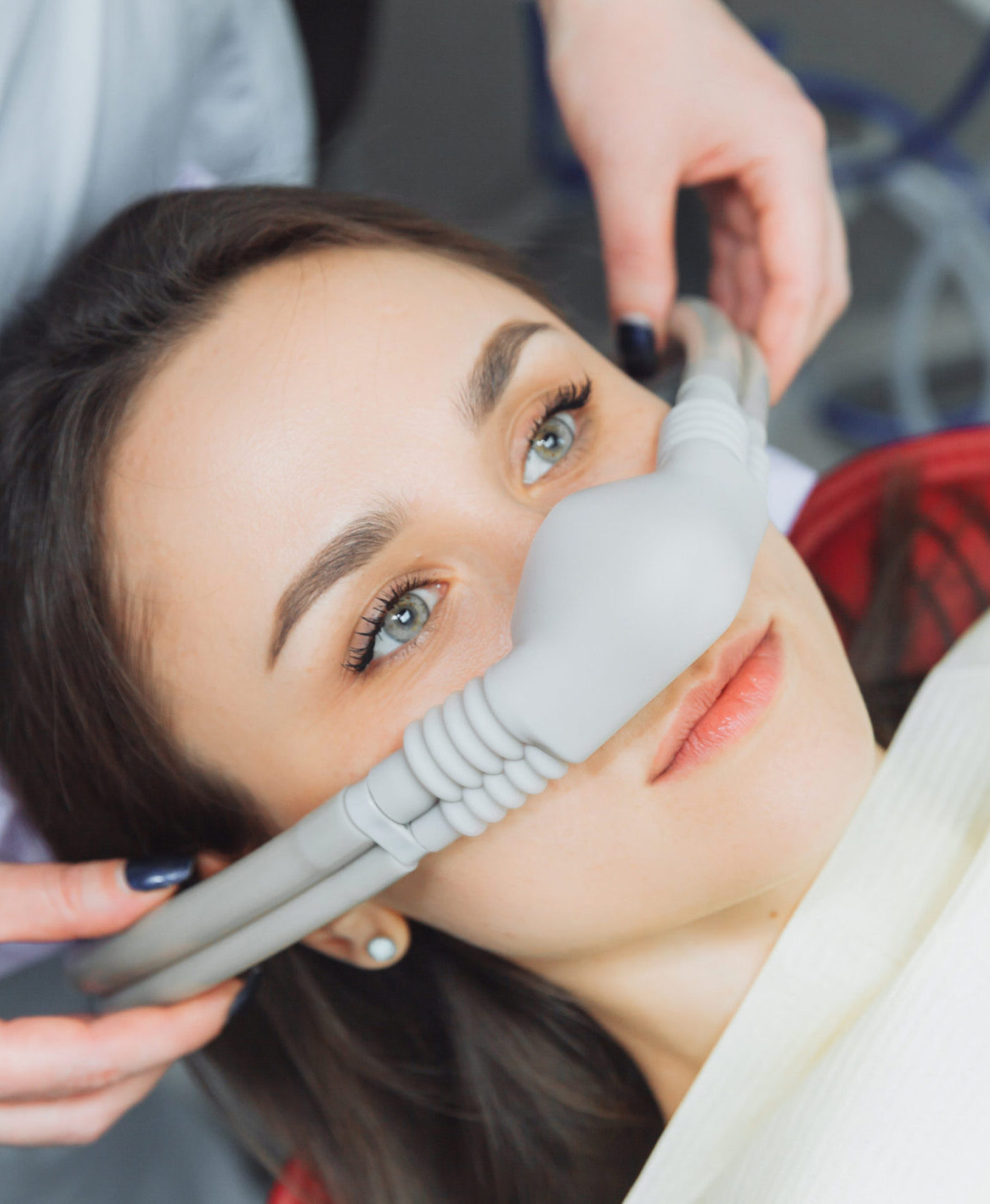 dentist puts inhalation sedative mask on his patient.