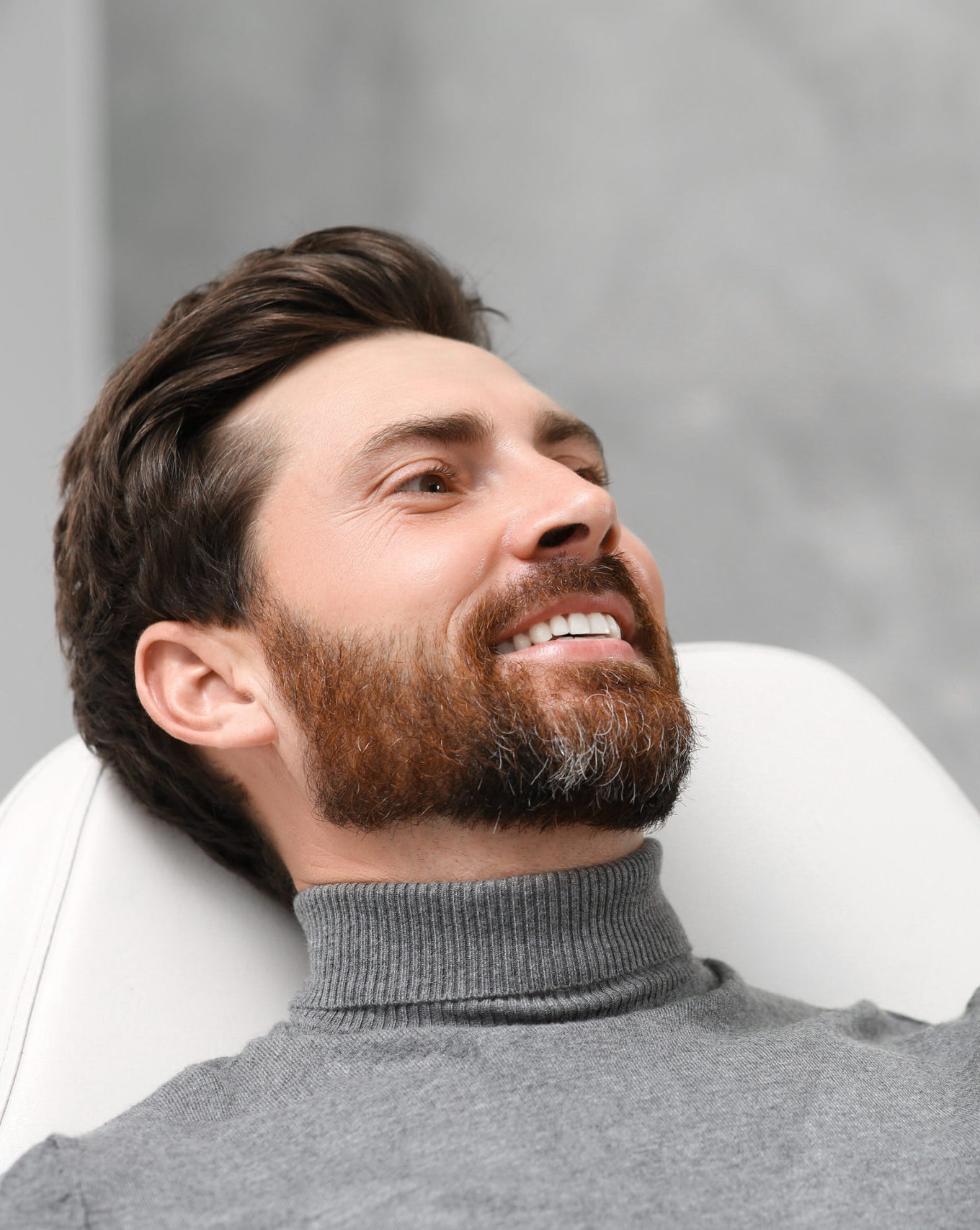 Man looking at his new dental implants in mirror indoors