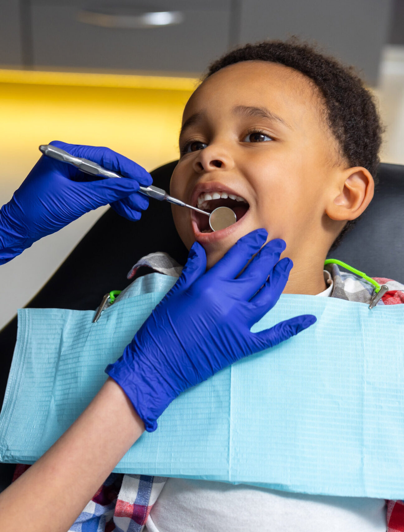 In dentistry. Female doctor checking up dark-skinned boy