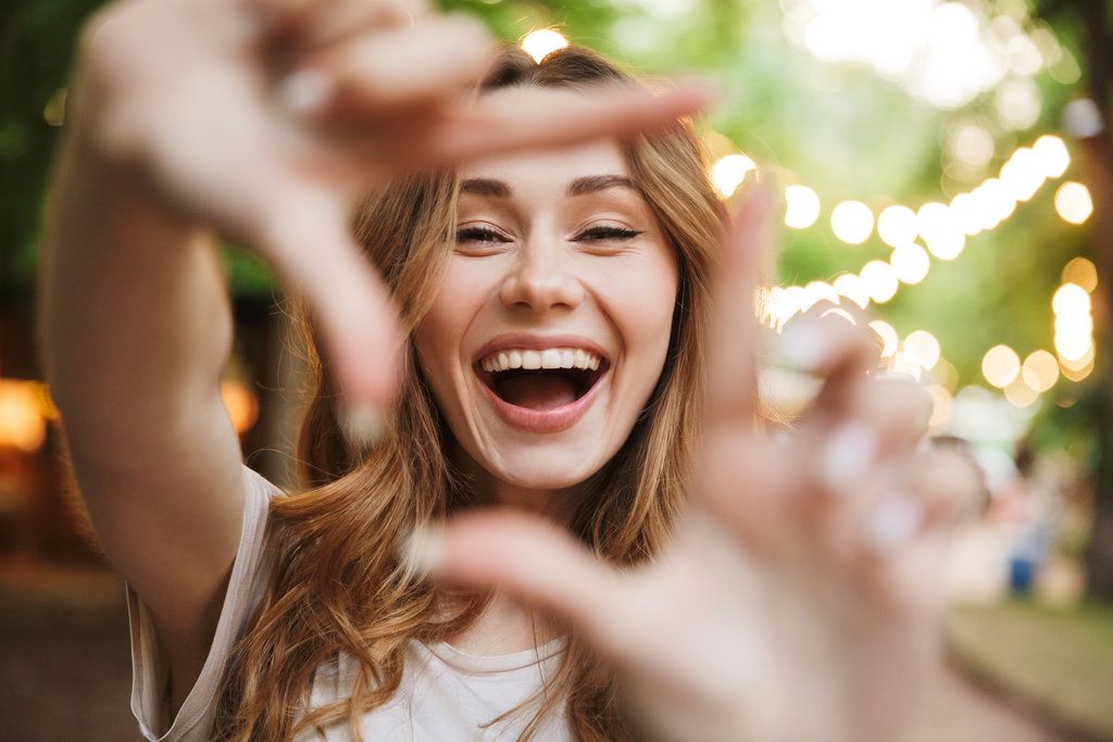 Smiling woman framing her face