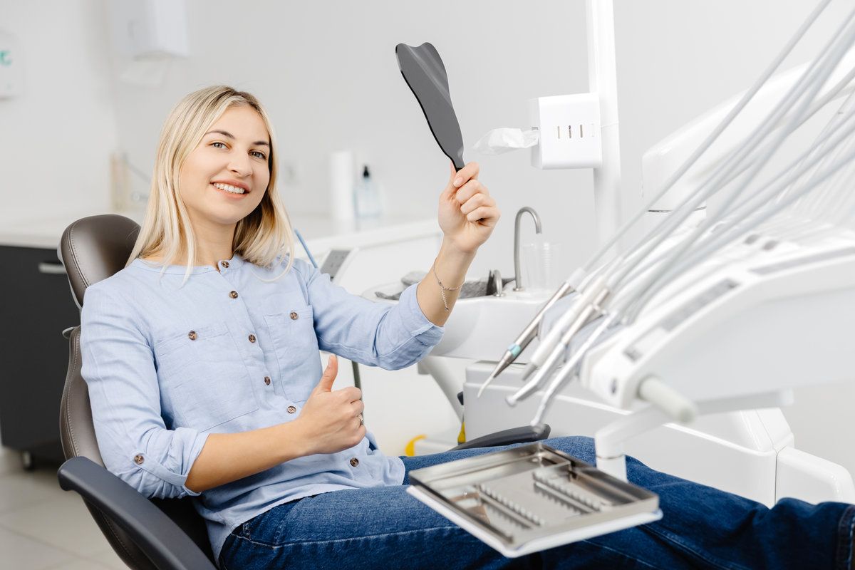Smiling woman in dental clinic chair.