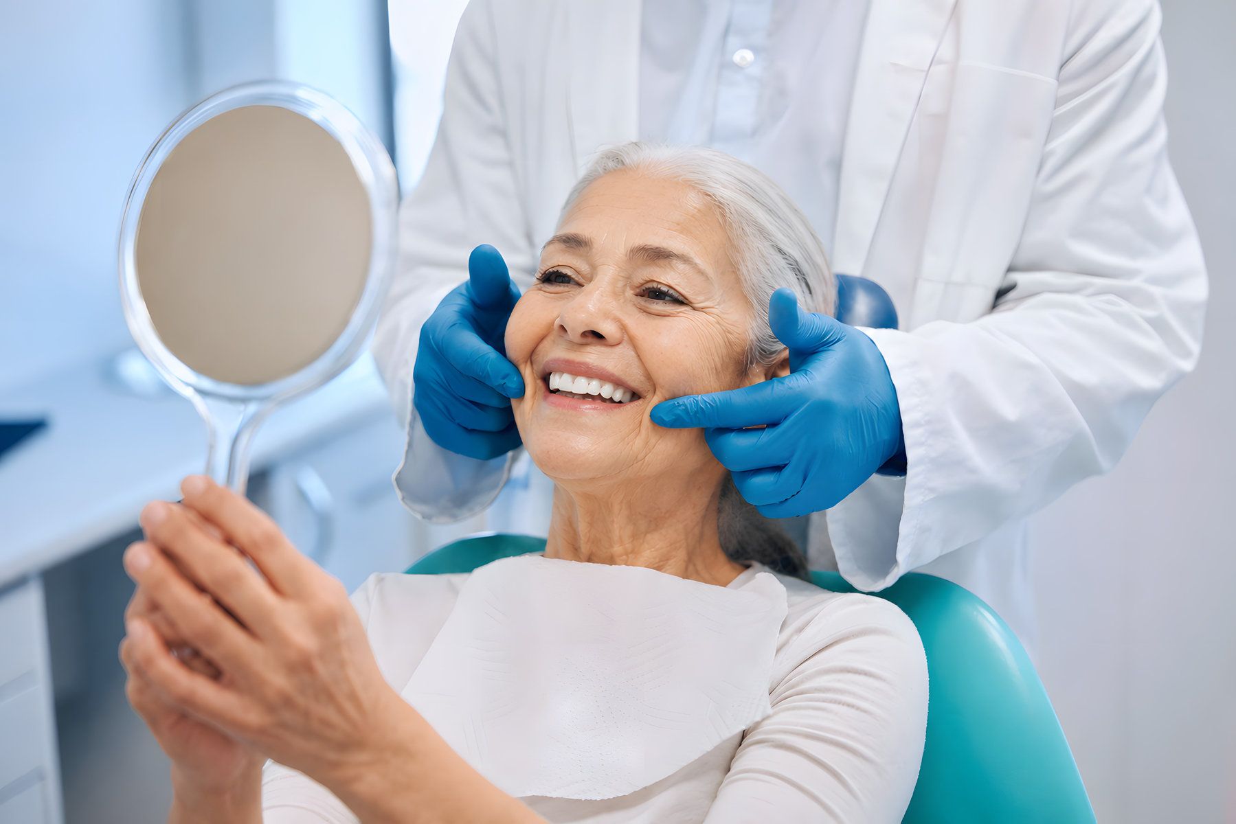 Elderly woman smiling at dentist's mirror