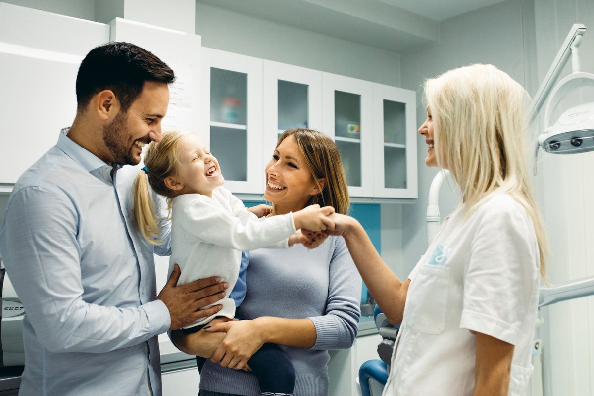 Family at a dental appointment, smiling.