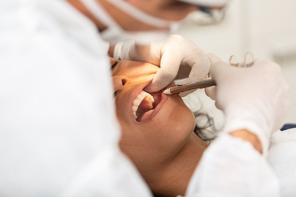 Young woman being seen in a dentist's office. Concept of toothache, wisdom tooth extraction, anesthesia, problems with caries or gums. Oral health care.